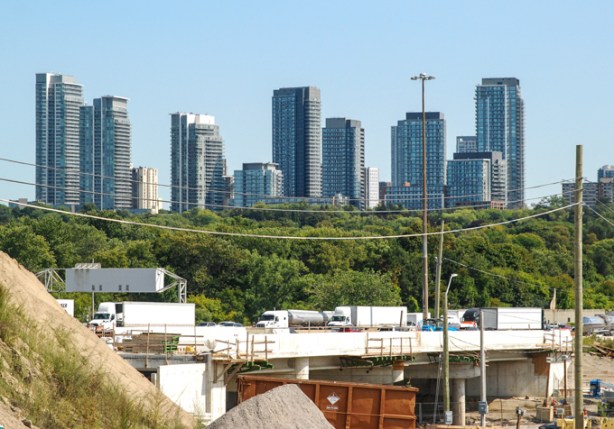 looking northeast from pedestrian bridge over GO tracks at oriole station, looking over the 401 to highrises in the distance