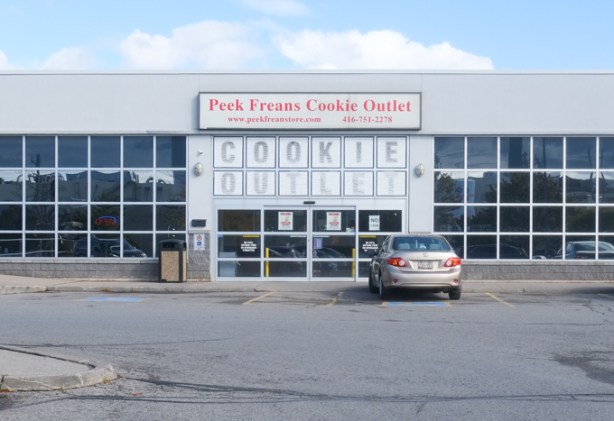 entrance to Peek freans cookie outlet, one car parked in front, mostly glass front to the building