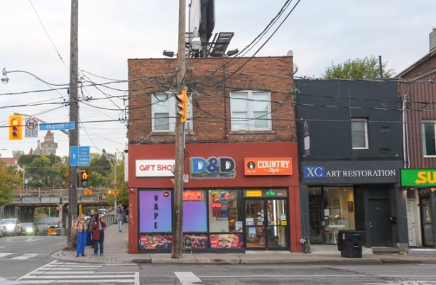 stores on northeast corner of spadina and dupont, pedestrians people waiting to cross at traffic light, D and D gift shop, country style, and XC Art Restoration, Subway restaurant