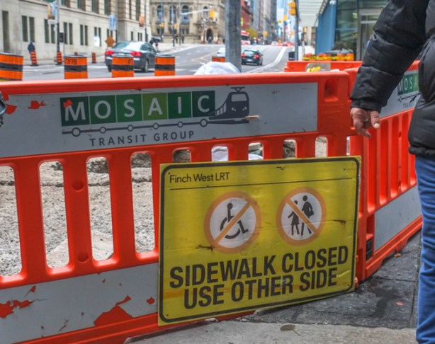 on yonge street, near The Esplanade, a sign saying sidewalk closed use other side, but it also says Finch West LRT