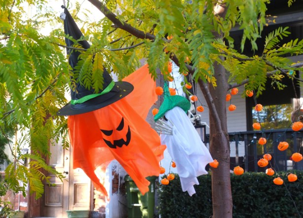 plastic halloween decorations, a flying orange ghostly creature with a black witch's hat on 
