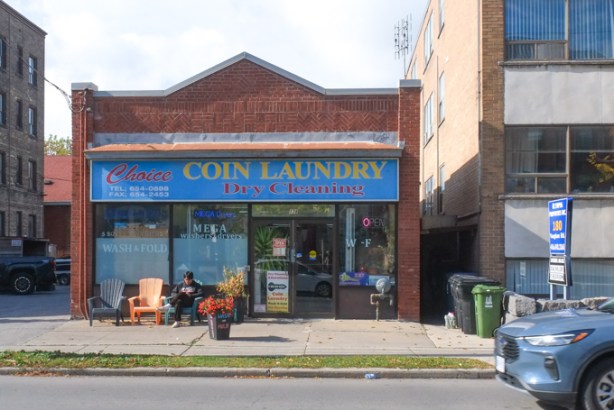 Choice coin laundry and dry cleaning, , with a young man sitting outside