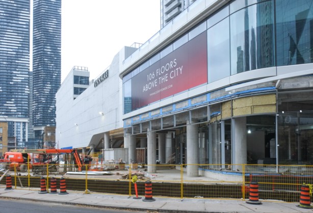 new condo tower under construction, pinnacle, large podium at first few floors with large sign advertising the fact that it is 106 floors high