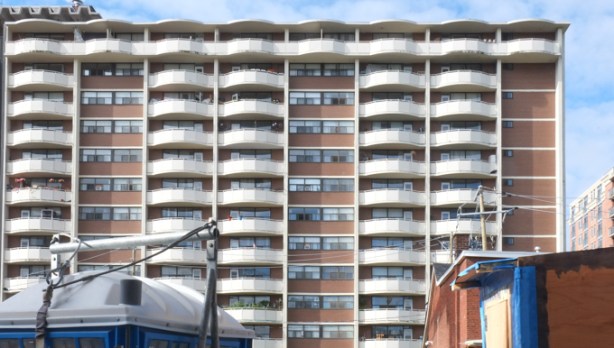 large apartment building in background, top of a porta potty in the foreground, 