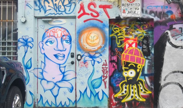 paint graffiti in graffiti alley, black octopus wearing a red toque