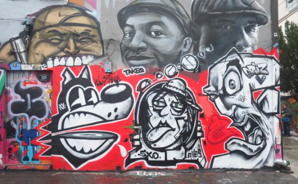 red, black, and white mural in graffiti alley