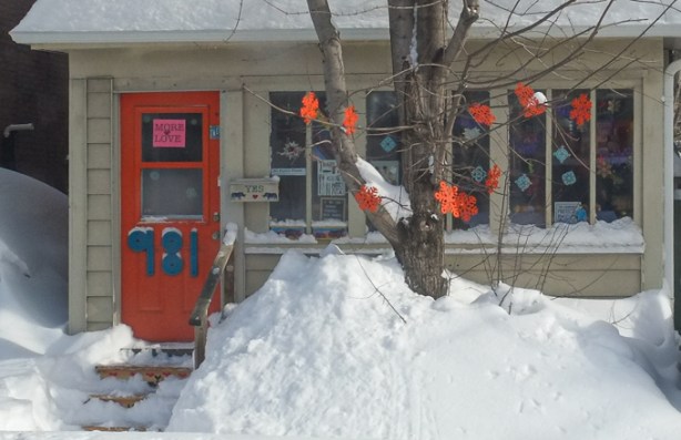 house, in winter, large numbers on front door, 981, also a sign that says more love,