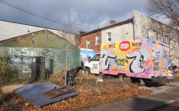 truck parked beside building, graffiti on back of truck