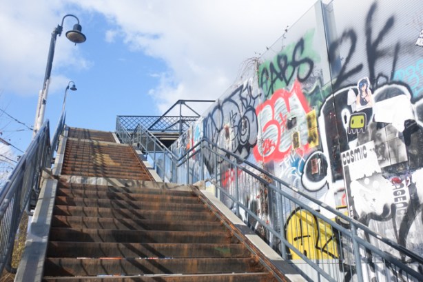 stairs to bridge over the railway, with graffiti on the wall