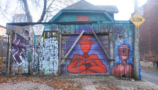 garage door with street art, red man with arms folded, maroon man, blue and teal background,
