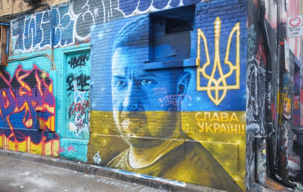 portrait of zelensky, ukrainian leader president, in blue and yellow, street art mural
