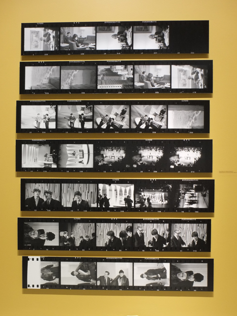 yellow wall at Art Gallery of Ontario covered with enlargements of negatives printed like a contact sheet. Pictures were from their television performances, like Ed Sullivan show, in the mid 1960s.