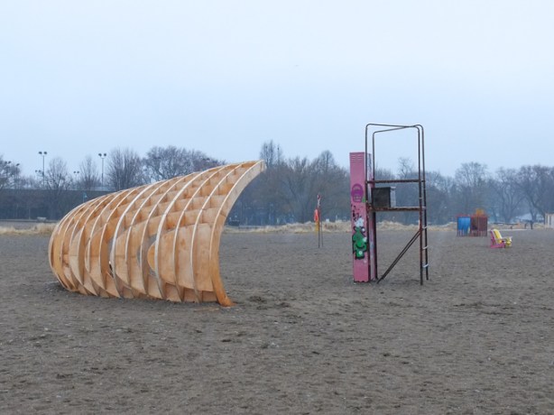 winter stations, public art installation at Woodbine beach, in late March, no snow, title is crest, curved structure made of wood