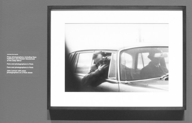 photo of two men in a car, one is aphotographer and is leaning out the window with his camera, 1960s, black and white photo