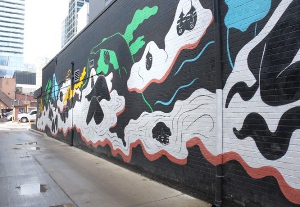 part of a mural by ness lee, black woman with long hair swimming or floating in white wavy water