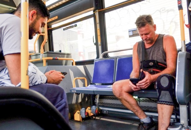 men riding on TTC bus, on phones
