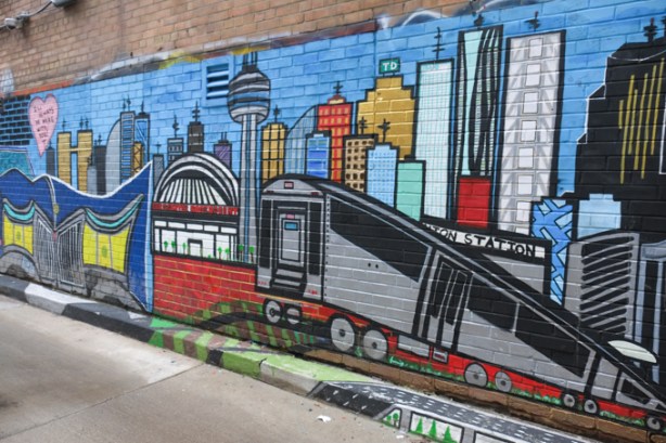 street art mural of downtown Toronto with CN tower, subway, union station rogers centre, tall buildings