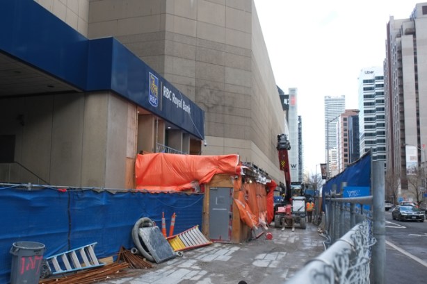 construction site on bloor takes over sidewalk in front of royal bank, beside old Hudsons Bay Co, the Bay, concrete building