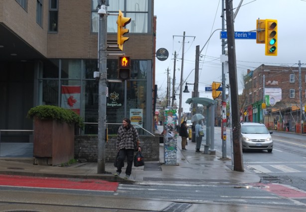 man crossing Dufferin st at Queen, looking west