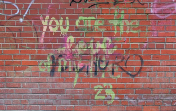 graffiti on a brick wall in yellow that says you are the love of my life