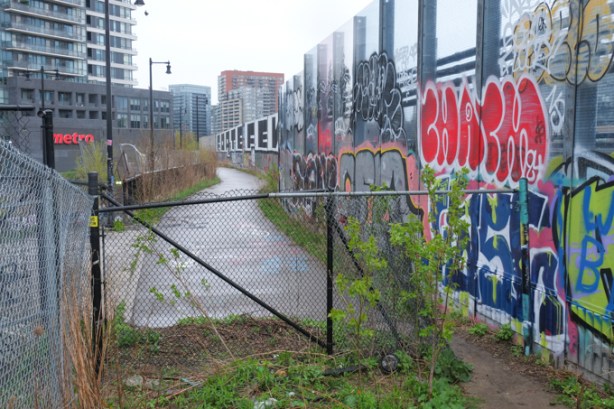 fence, pedestrian crossing for bridge, with lots of graffiti on it, 