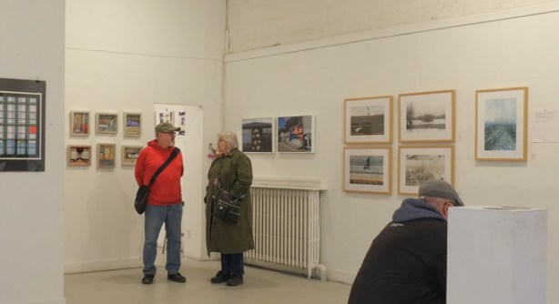 two people in a gallery looking at photographs and talking to each other, Gallery 1313