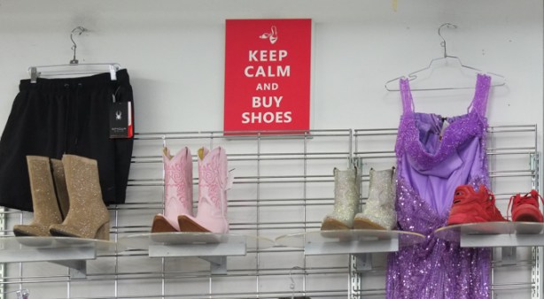 keep calm and buy shoes poster on the wall of a store