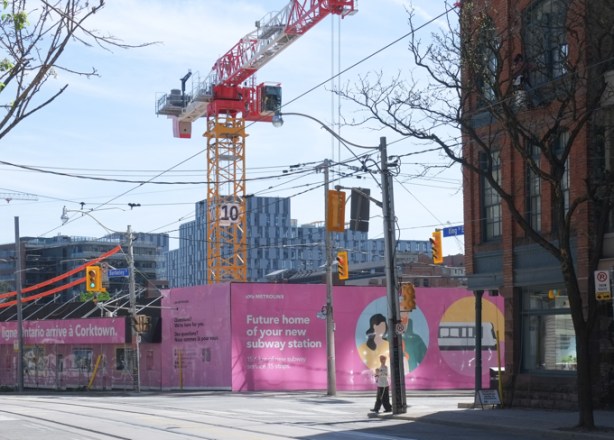 a person crosses King street at Berkley, looking southeast towards metrolinx construction of Ontario line
