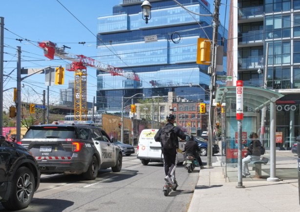 at king and parliament, waiting for traffic lights to turn green, police car, cyclist and man on a scooter