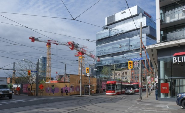 King and Parliament streets, looking south west, Ontario line construction hoardings, Globe and Mail building in the background