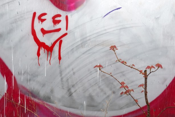 little red graffiti face on white paint