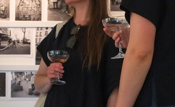 2 women drinking white wine in an art gallery