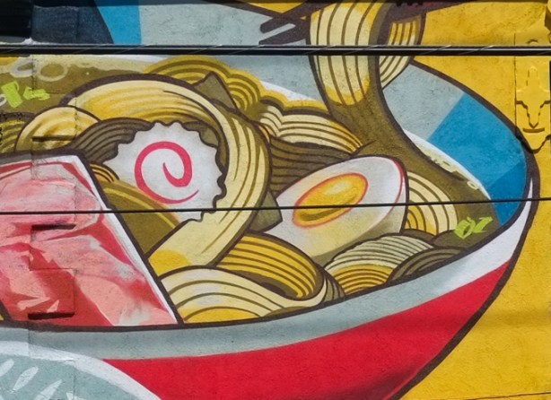 a portion of Japan Town 5 mural on the side of Sanko Trading Company store on Queen Street West, chopsticks reaching into a soup bowl with egg, noodles, and a bit of pinkish meat