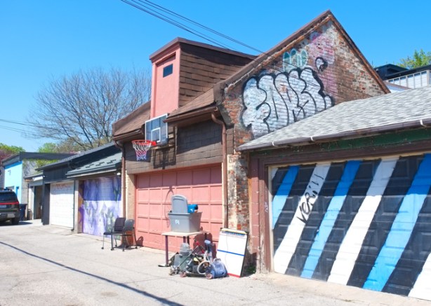 alley views, garage door in blue, black, and white diagonal stripes
