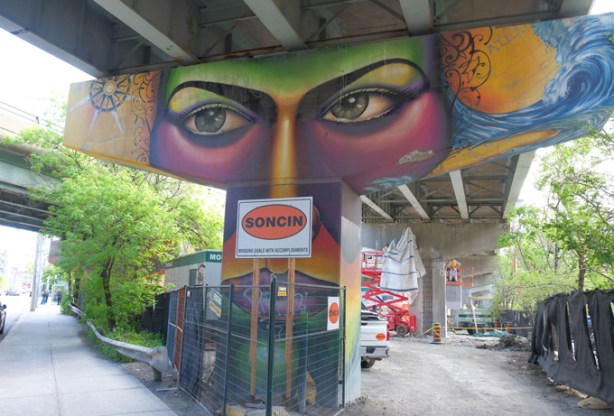 shalak attack and bruno smoky painting of a person, face, large eyes, on concrete support pillar of overhead ramp