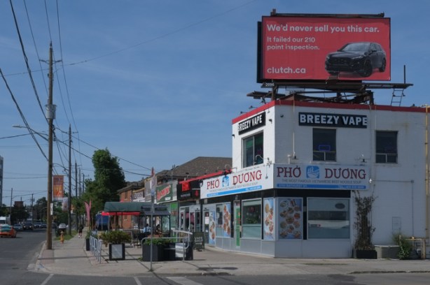 businesses on Bathurst, north of Wilson, inclusing breezy vapes, also pho duong vietnamese restaurant, billboard on top of building for clutch dot ca, 