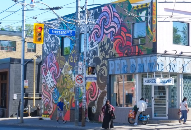 large Rowell Soller mural on a building that is on the southwest corner of Coxwell and Gerrard