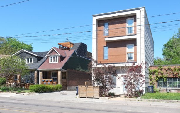 square three storey residence, beside older single family home that has new rootop terrace