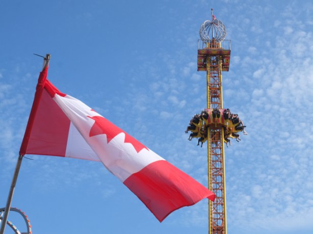 Canadian flag flying, with CNE ride in the background
