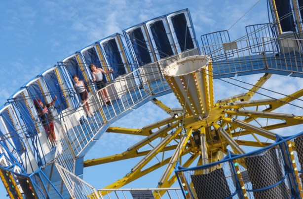three kids riding on zero gravity ride at the ex midway