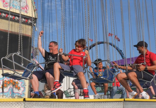 people sitting in swings waiting for ride to start, Canadian National Exhibition, midway,