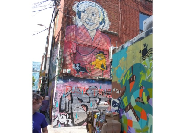 uber5000 mural in graffiti alley, yellow birdie is walking dog, woman with headphones, on brick wall, 