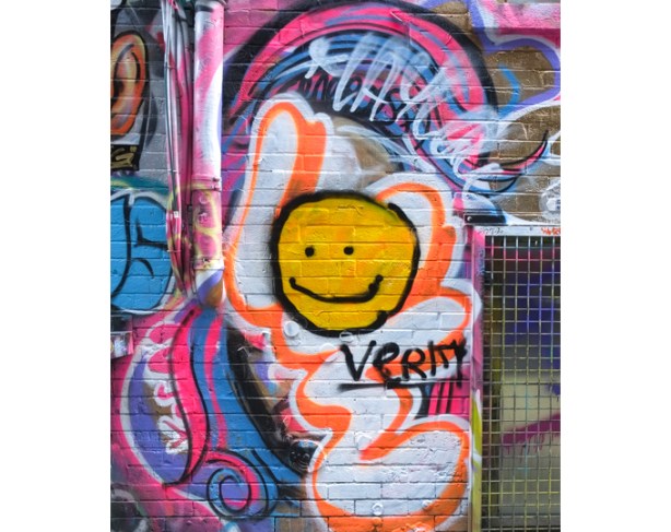 graffiti, including a yellow happy face and the word verity