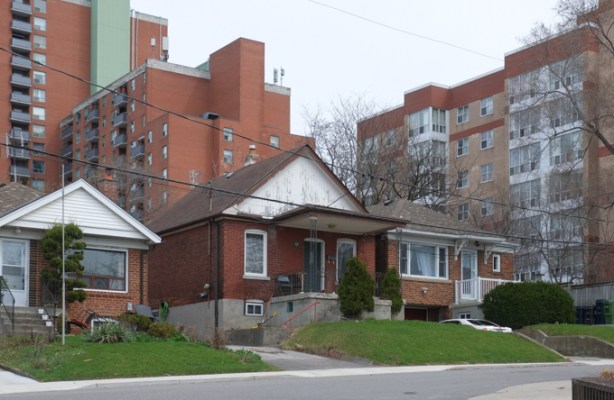 small older houses in front, larger apartment buildings behind them