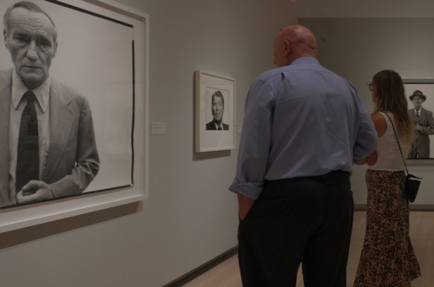 people looking at photographs in a gallery, black and white portraits by Richard Avedon