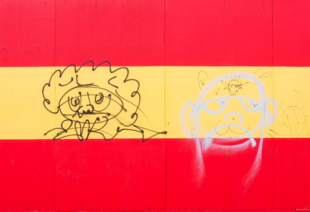 black marker drawings on red and yellow striped hoardings