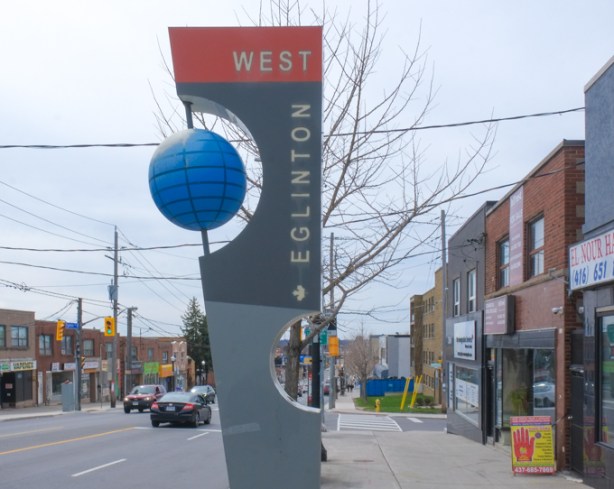 eglinton west sign, large vertical post with a blue globe 