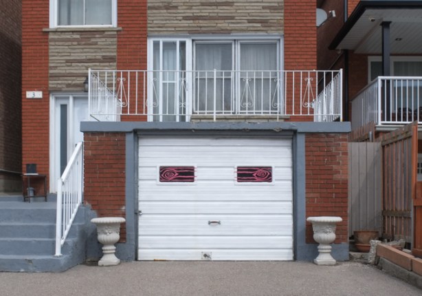 house with white garage, two small windows on garage that have been painted to look like eyes