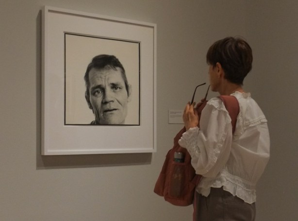people looking at photographs in a gallery, black and white portraits by Richard Avedon