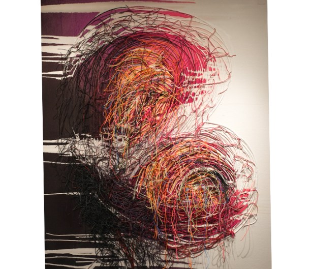 artwork by Lu Luo made of threads in mostly reds with some yellow and orange, 180 cm by 160 cm, looks like two cupped hands holding two swirls of threads and colours. 